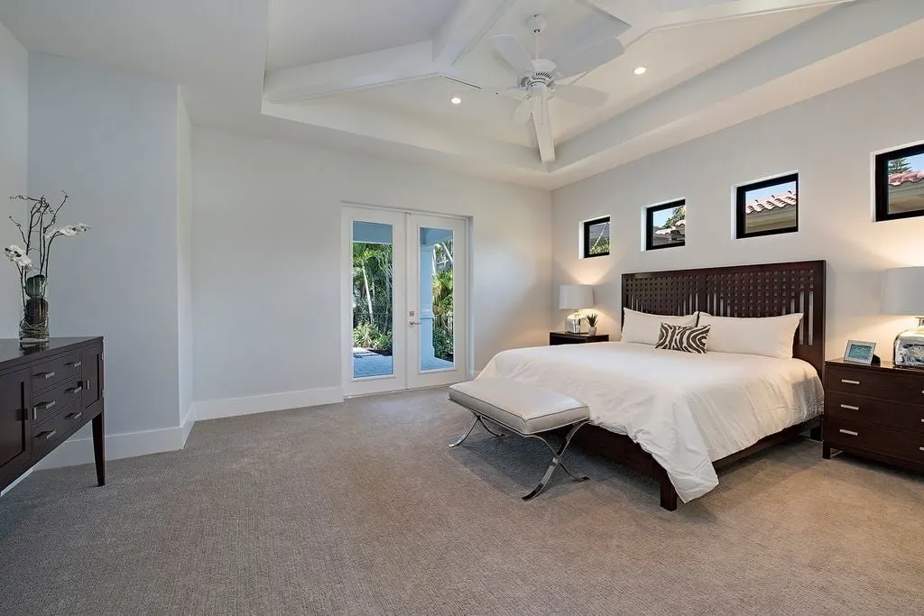 Master bedroom with a brightly colored interior design and a door leading to the covered lanai.