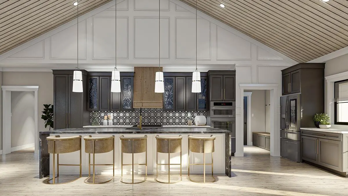 The kitchen island with a black marble countertop complements the gold tone elegant stools.