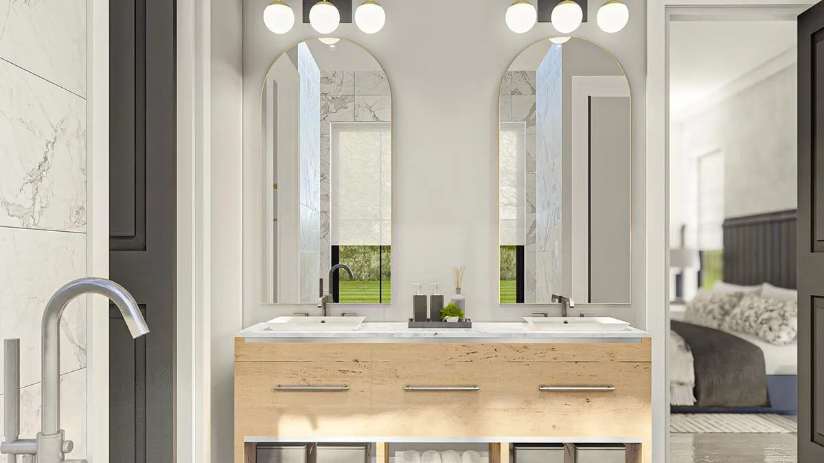 Vanity area with arched style mirror and light bright wood drawers.