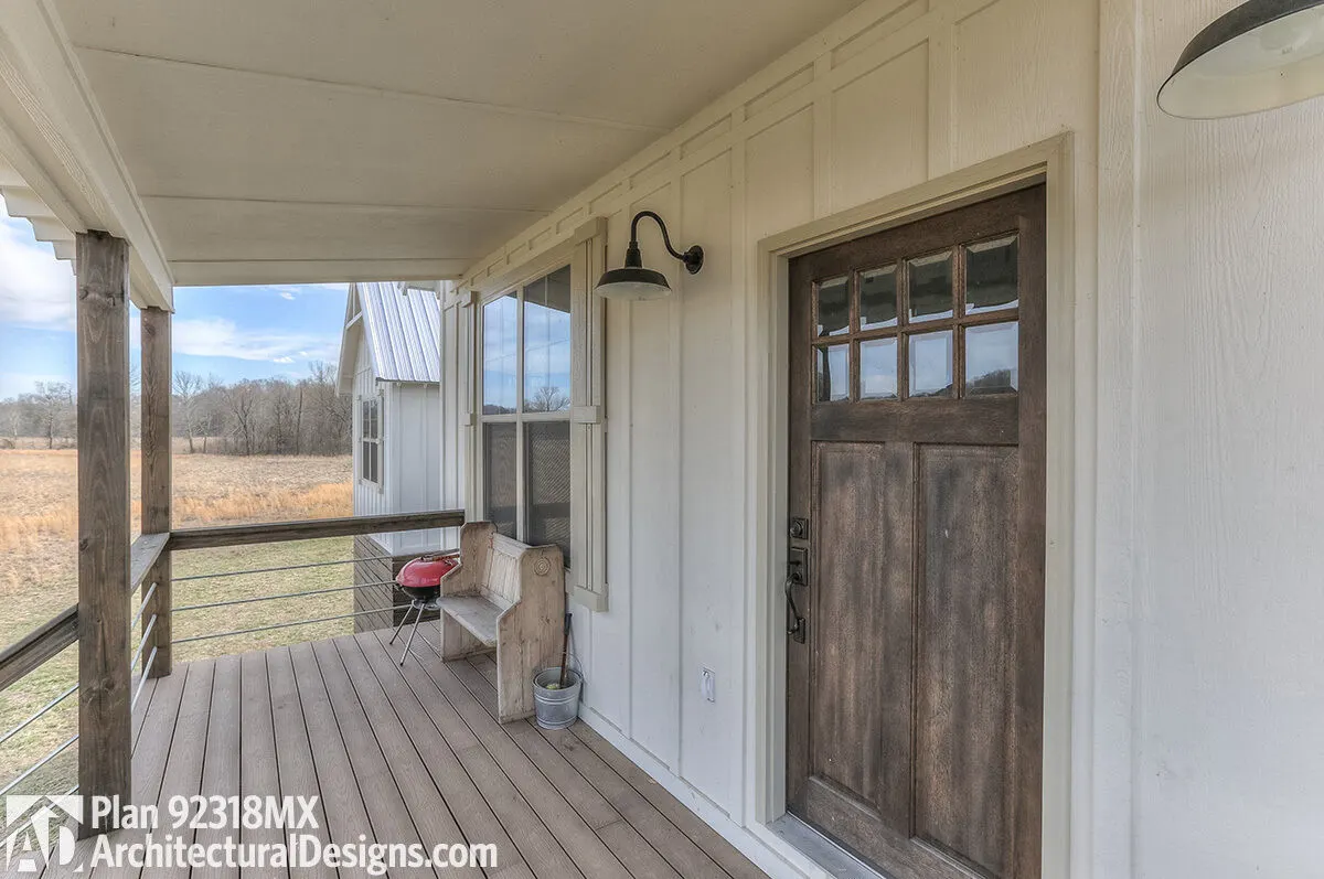 Wood flooring surrounds the porch area, and the main door has a glass accent.