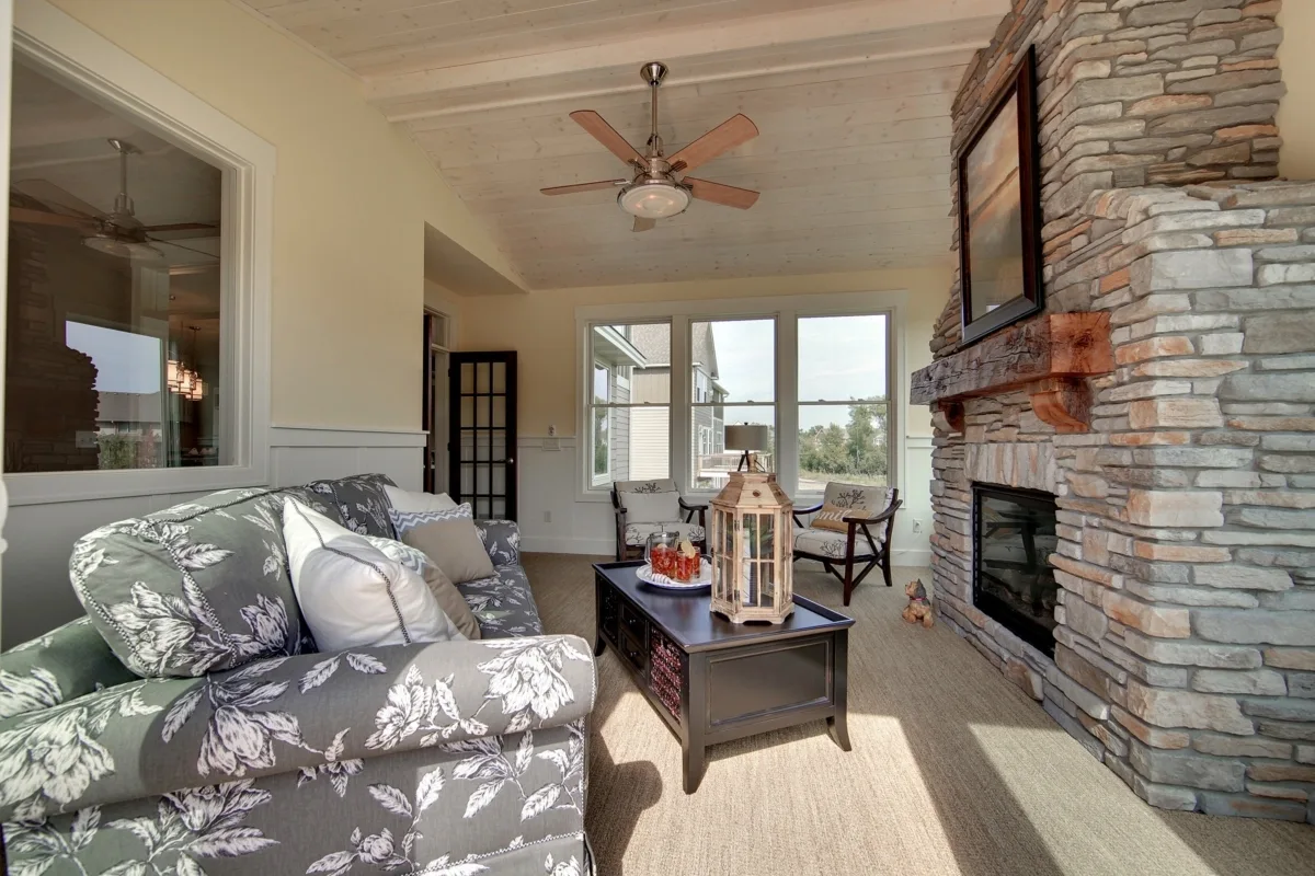 The porch area with comfortable seats with gray and white tone flower coverings.