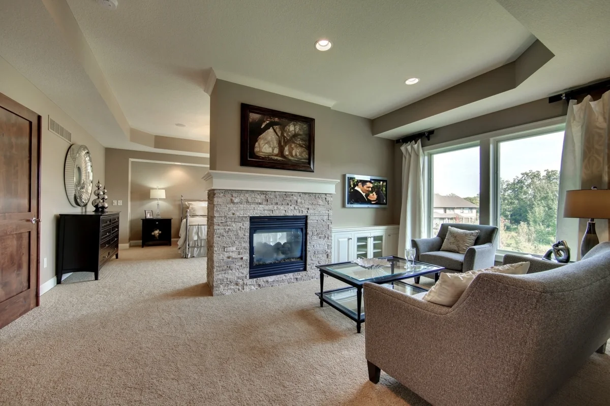 Stone foundation and black frame wood burner fireplace in the sitting room.