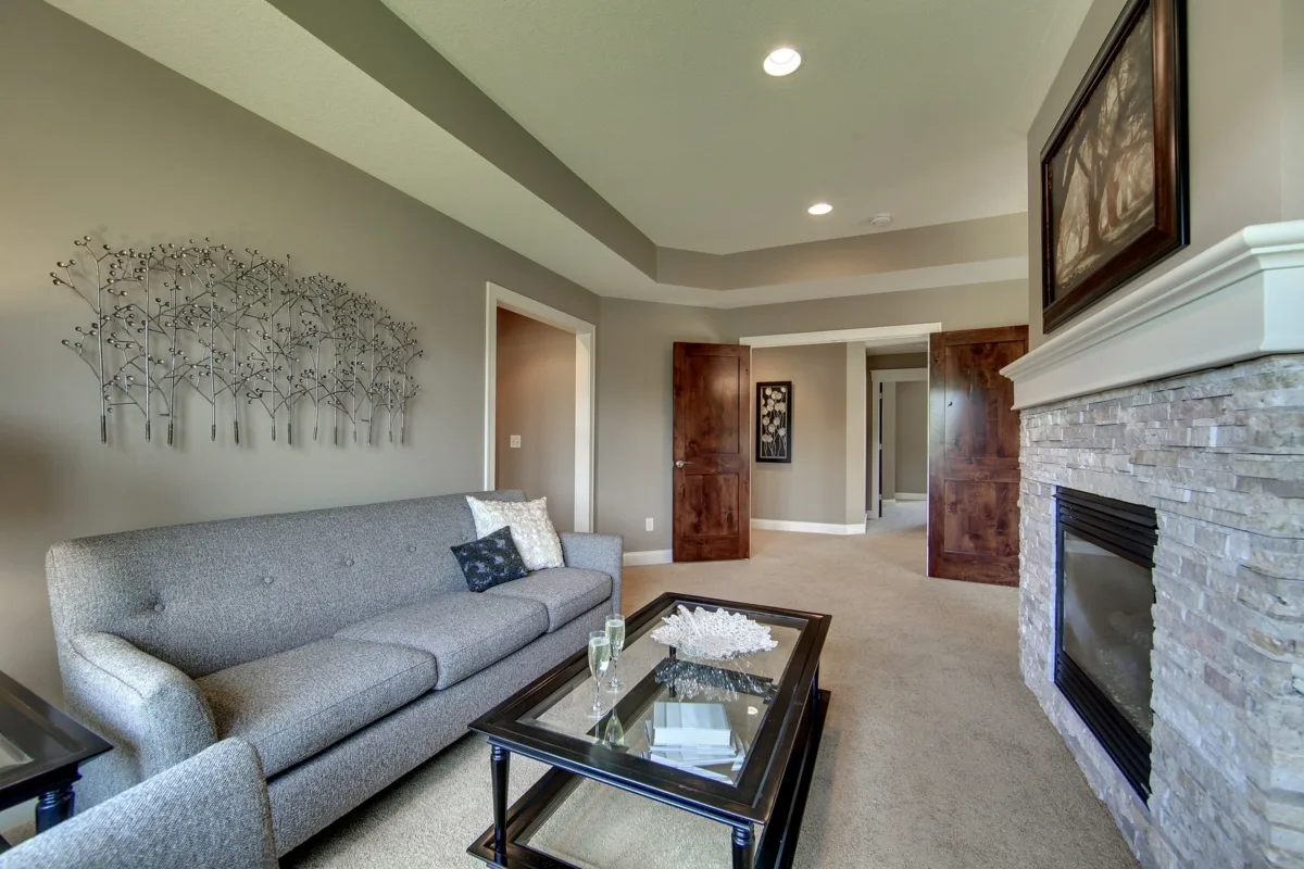 Elegant sitting space with gray sofa and tray ceiling design.