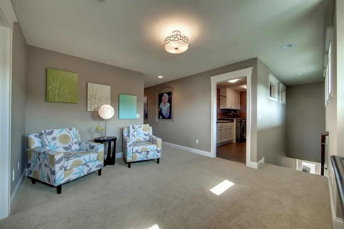 Beautiful loft space with flowery seat covers near the stairs.