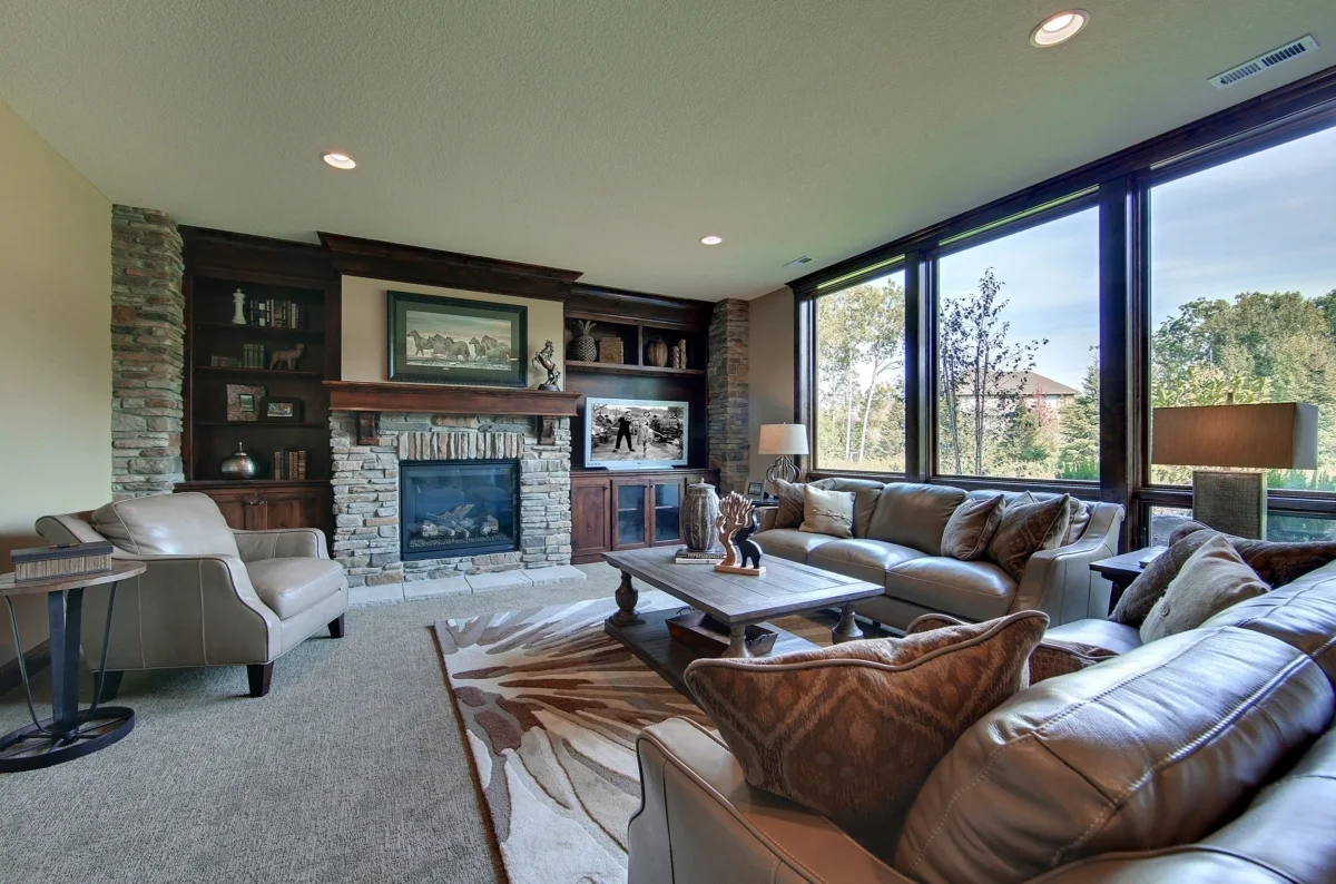 The family room includes a fireplace and a leather sofa set.