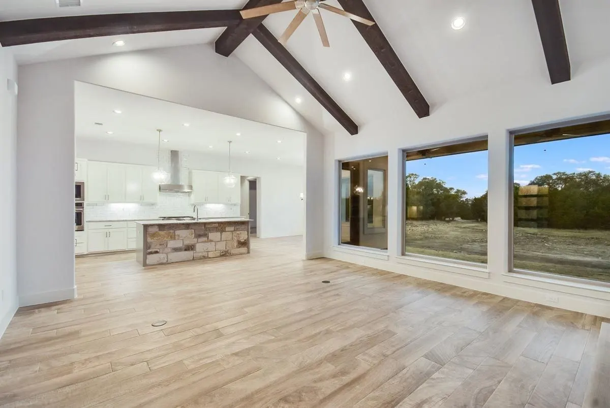 Large windows in the living room area provide views of the outdoors.