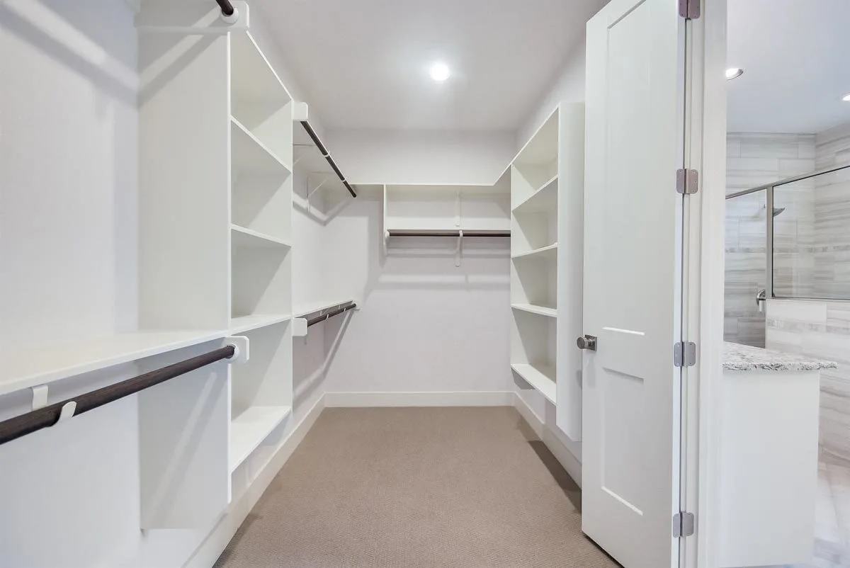 Master closet in spacious racks and shelves with rods.