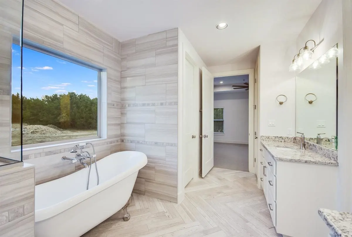 A sizable glass window provides the bathtub area with a view of the outside.