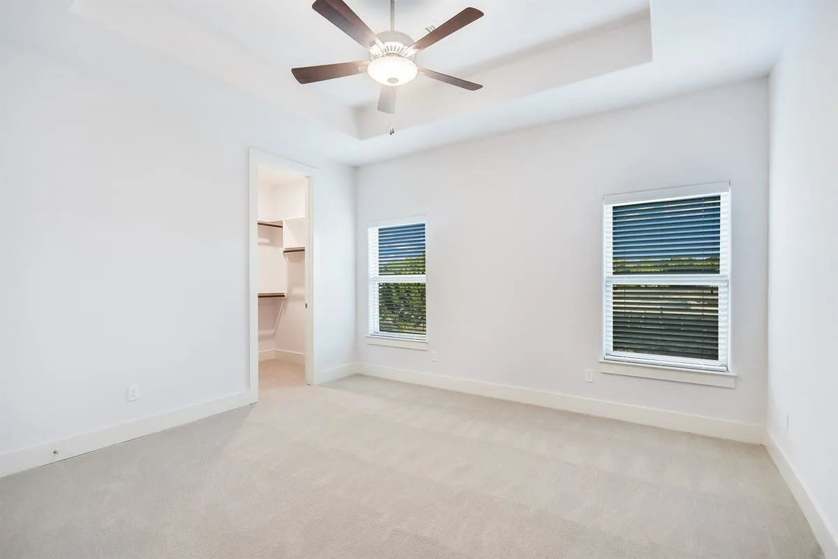 Bedroom area with windows in white trim and extra closet space.