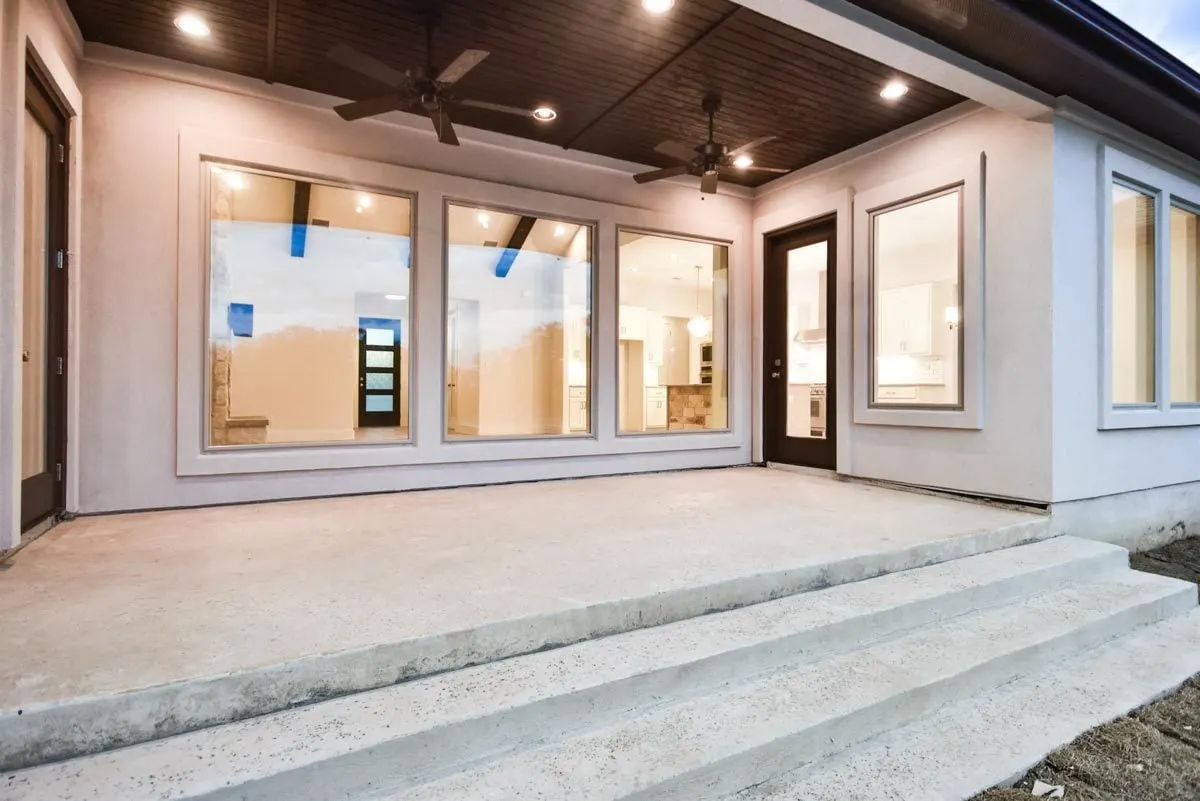 The rear porch area with a spacious stone floor and steps to the yard.