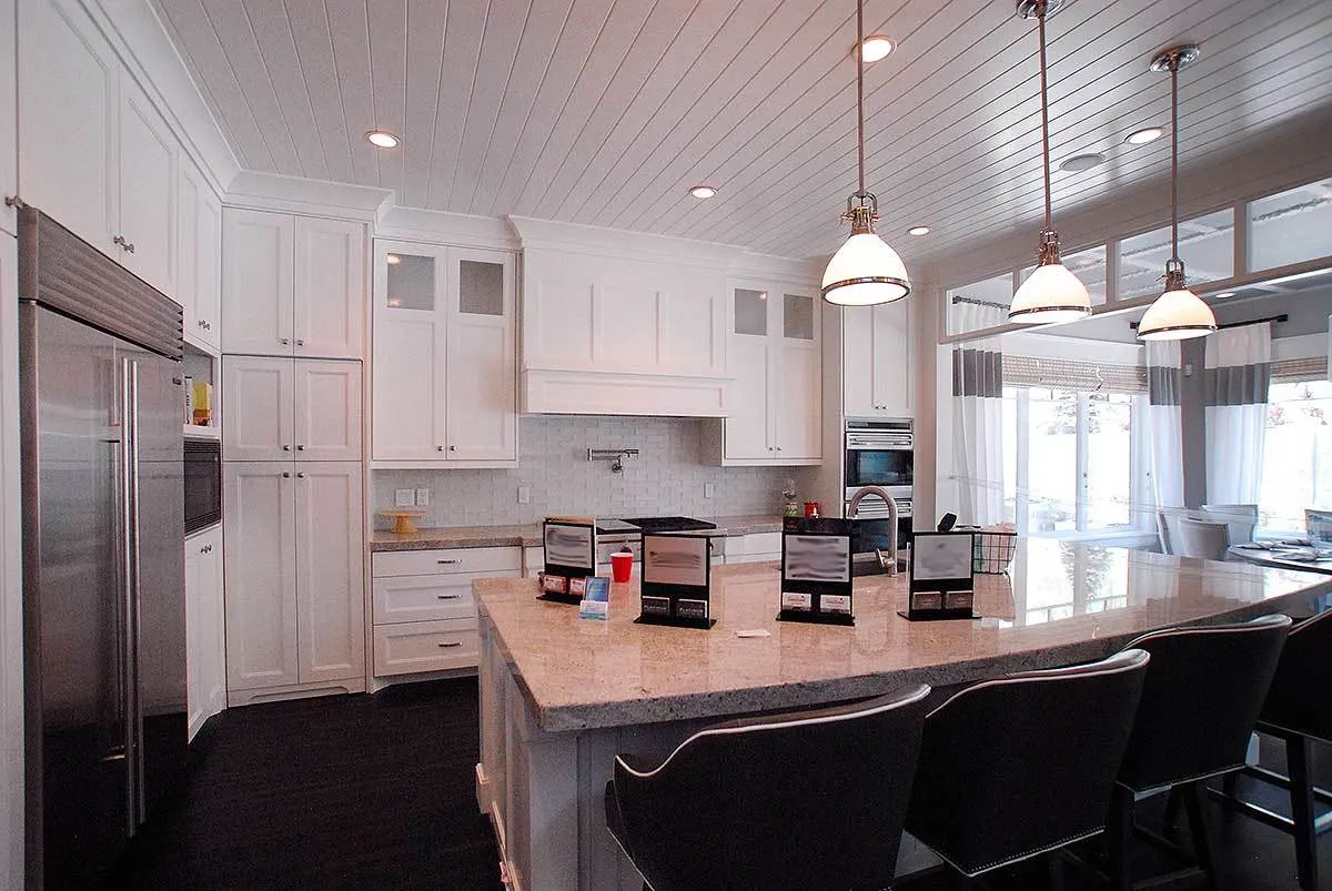 Bright kitchen interior with an island in beige marble counter.