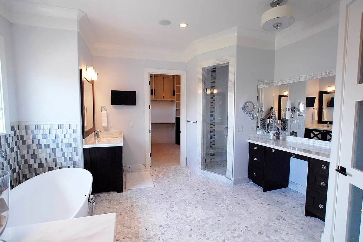 Master bathroom area in black and white interior tile with complete amenities.