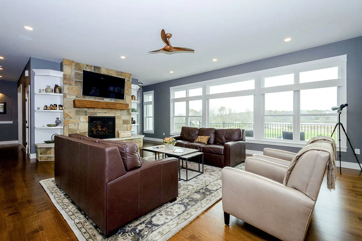 Great room with leathered sofa and fireplace in the stone foundation.